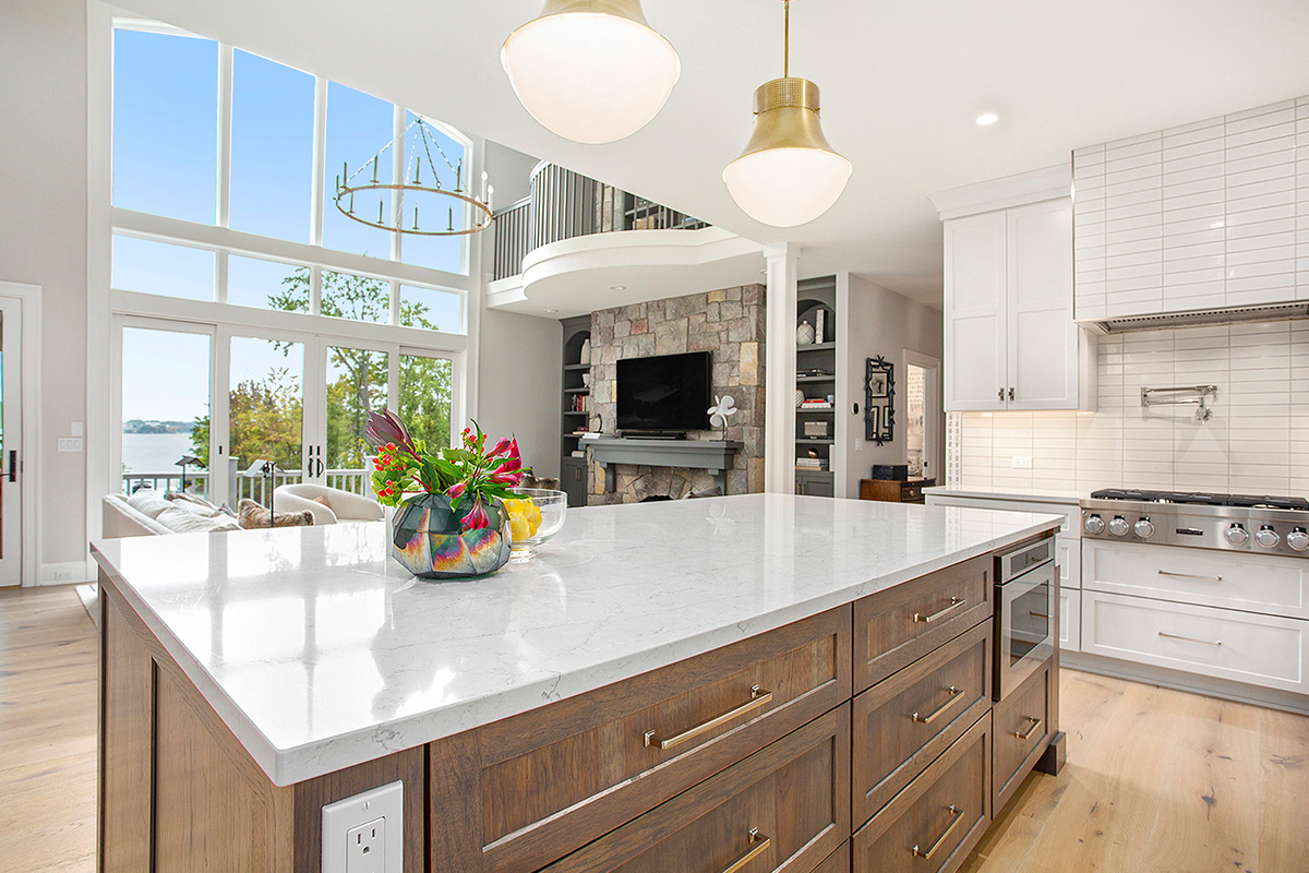 White kitchen cabinets with stained hickory island.