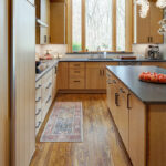 Light brown stained kitchen with island seating.