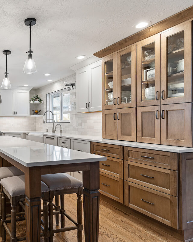 White and Cashew stained kitchen cabinets with long island with seating