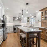 White and Cashew stained kitchen cabinets with long island with seating