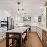 White and Cashew stained kitchen cabinets with long island with seating