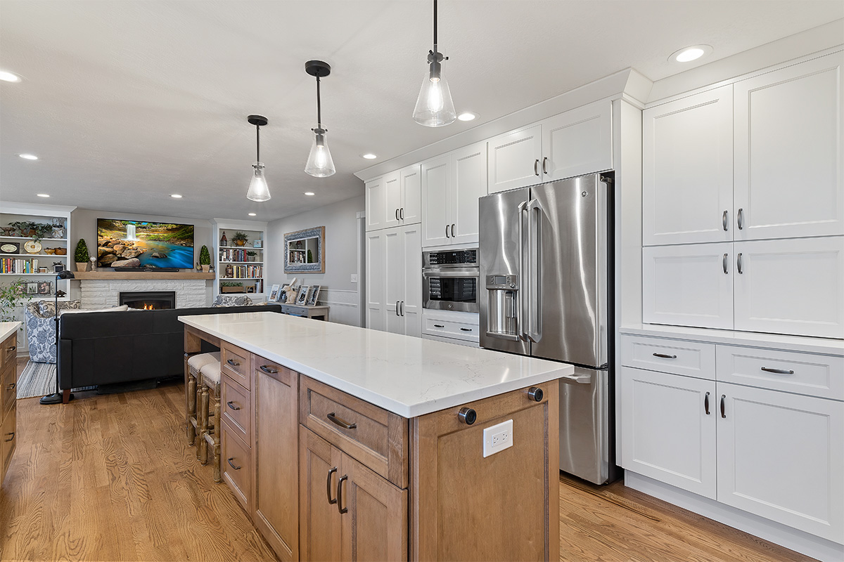 White and Cashew stained kitchen cabinets with long island with seating