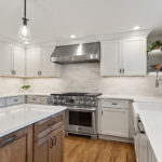 White and Cashew stained kitchen cabinets with long island with seating
