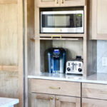 Cashew-stained kitchen cabinets with appliance storage