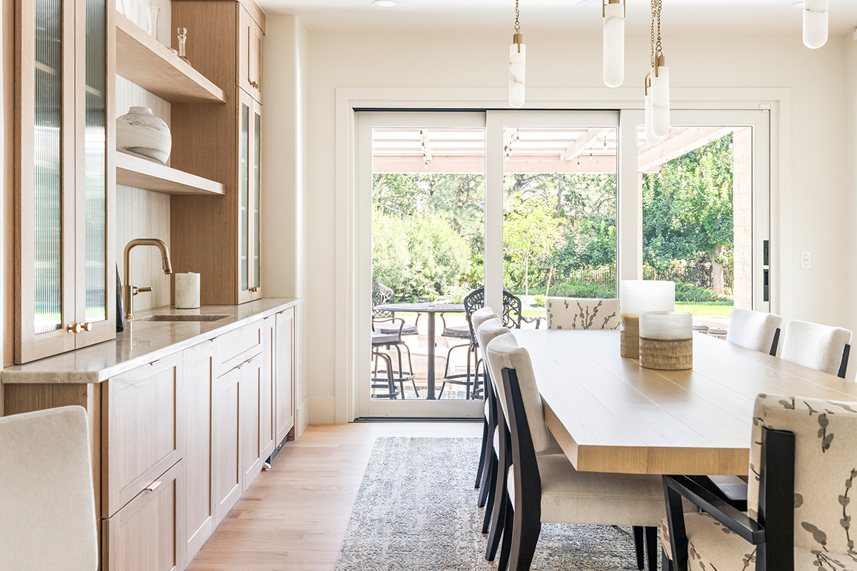 Light stained dining room serving station with table and chairs.