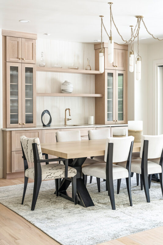 Light stained dining room serving station with table and chairs.