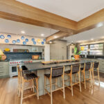 Brown painted kitchen with island and wood beams.