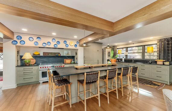 Brown painted kitchen with island and wood beams.