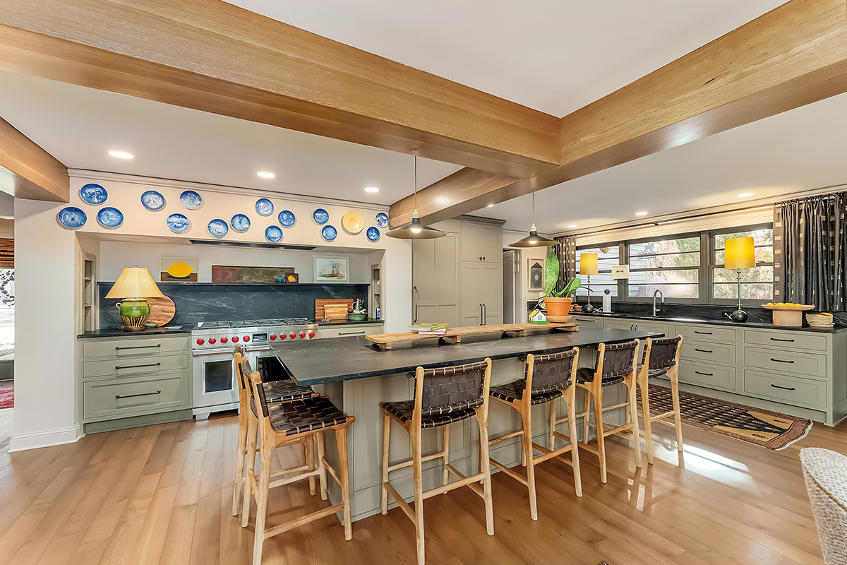 Brown painted kitchen with island and wood beams.