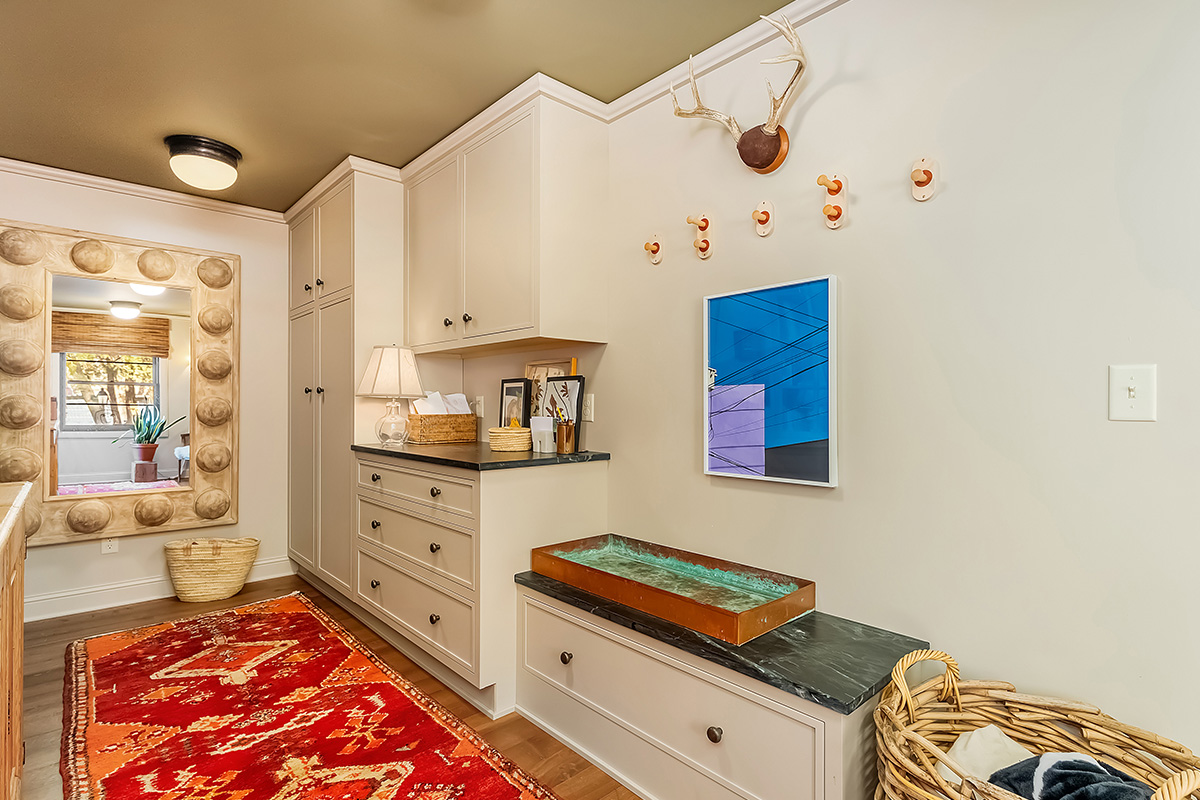 Light brown painted mudroom cabinets with bench seating.
