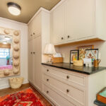 Light brown painted mudroom cabinets with bench seating.
