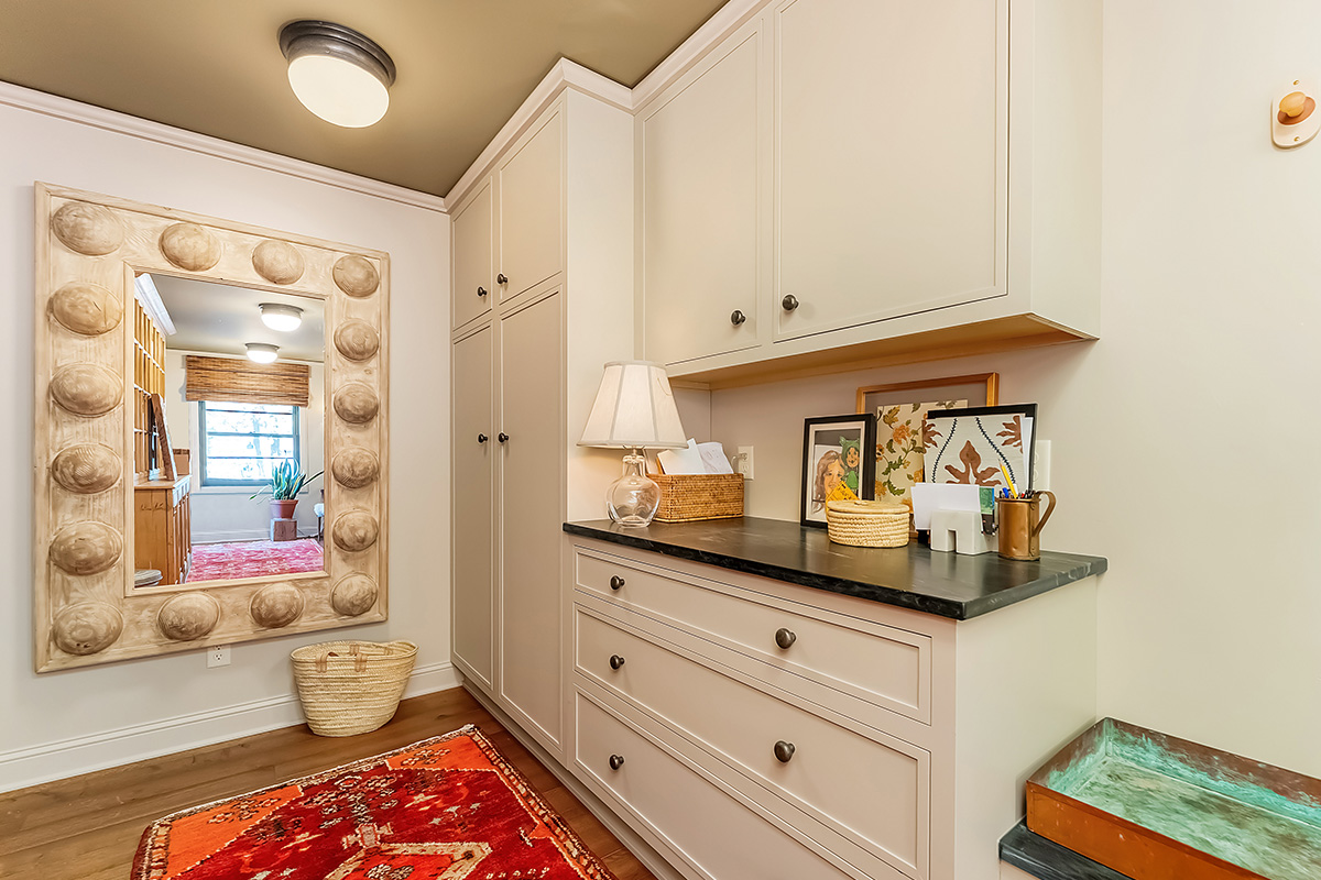 Light brown painted mudroom cabinets with bench seating.