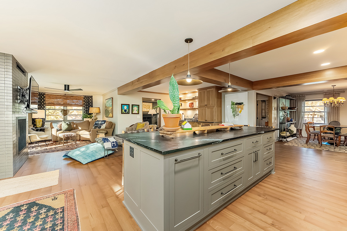Brown painted kitchen with island and wood beams.