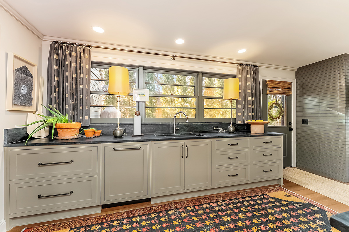 Brown painted kitchen with island and wood beams.