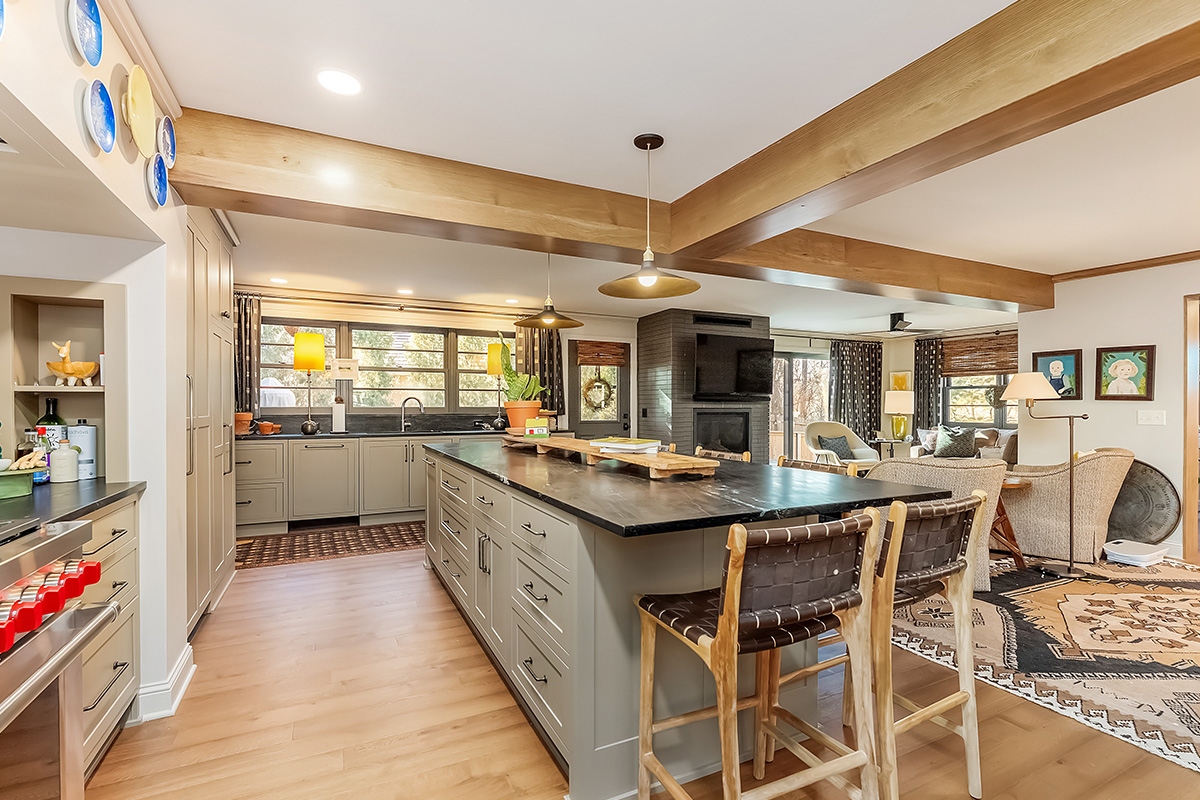 Brown painted kitchen with island and wood beams.