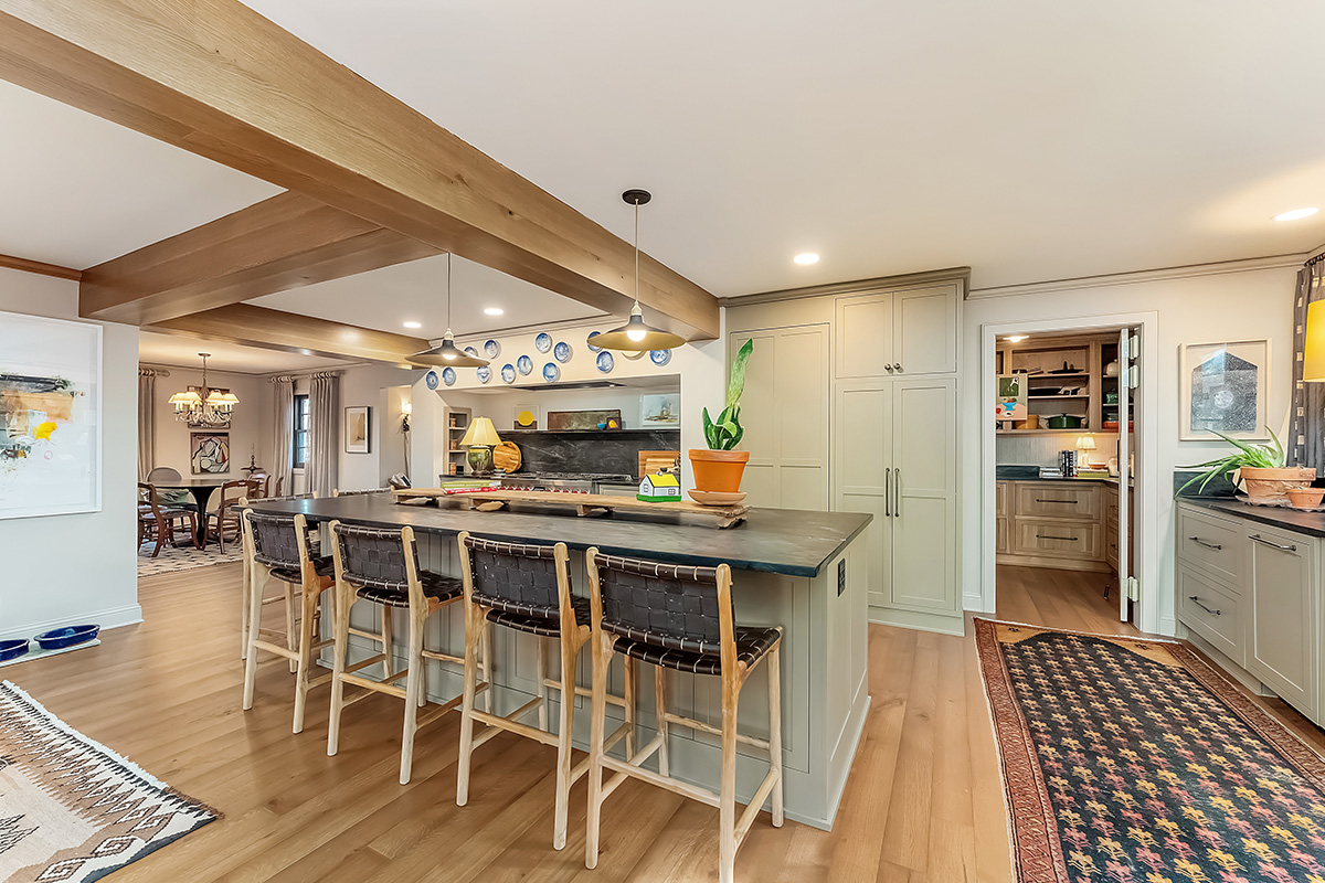 Brown painted kitchen with island and wood beams.