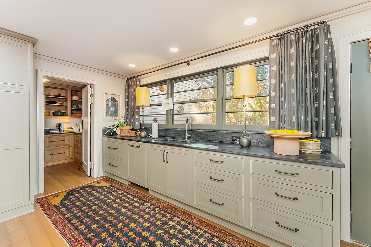 Brown painted kitchen with island and wood beams.
