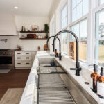 White kitchen cabinets with large row of windows above.