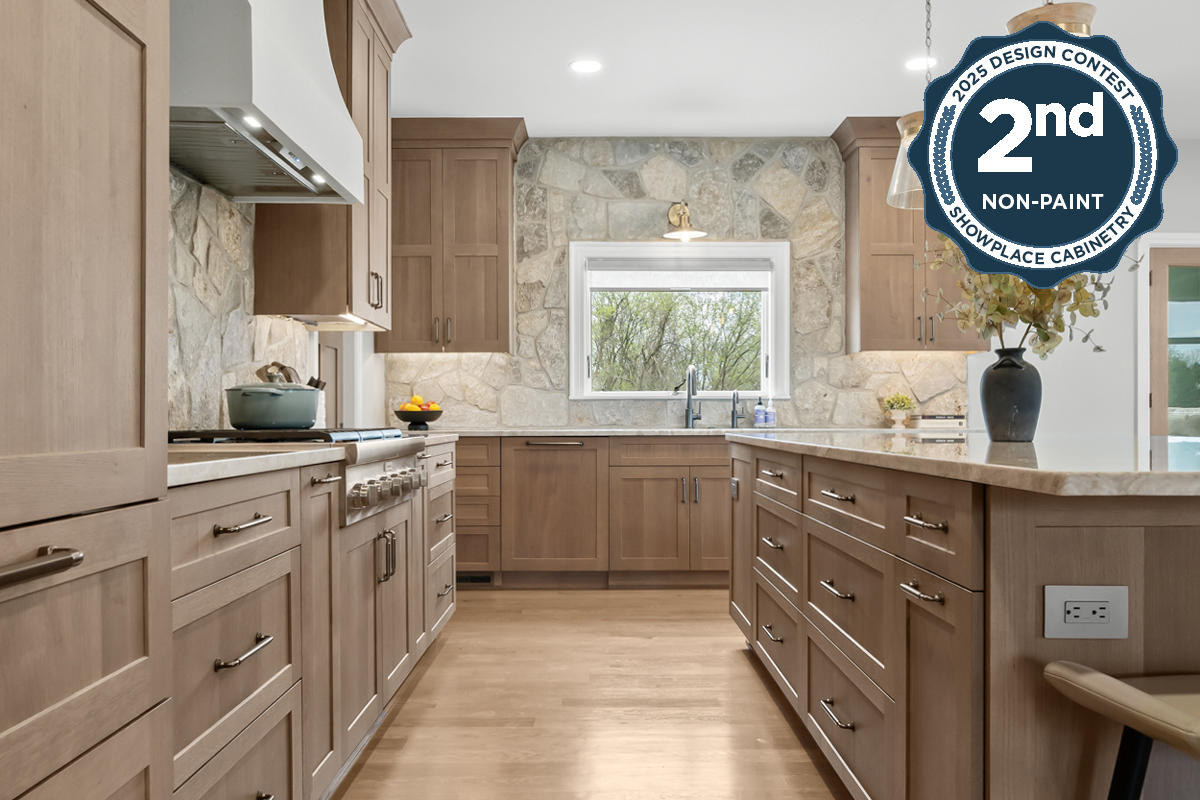Light stained kitchen cabinets on stone wall.