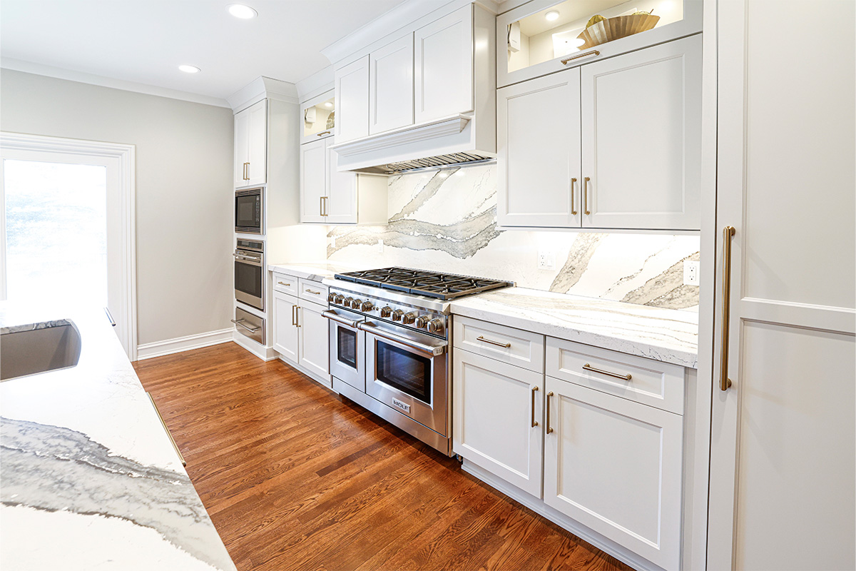 White kitchen cabinets showing hood and stove.