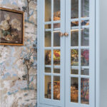 Light blue bathroom vanity cabinets with glass mullion doors.