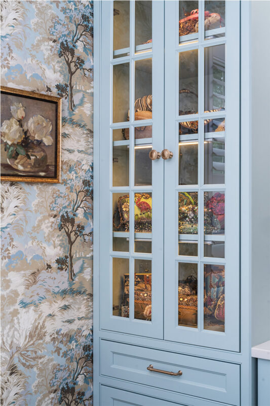Light blue bathroom vanity cabinets with glass mullion doors.