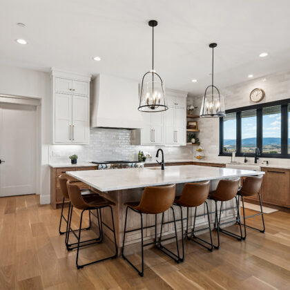 White painted and light brown stained kitchen with island.