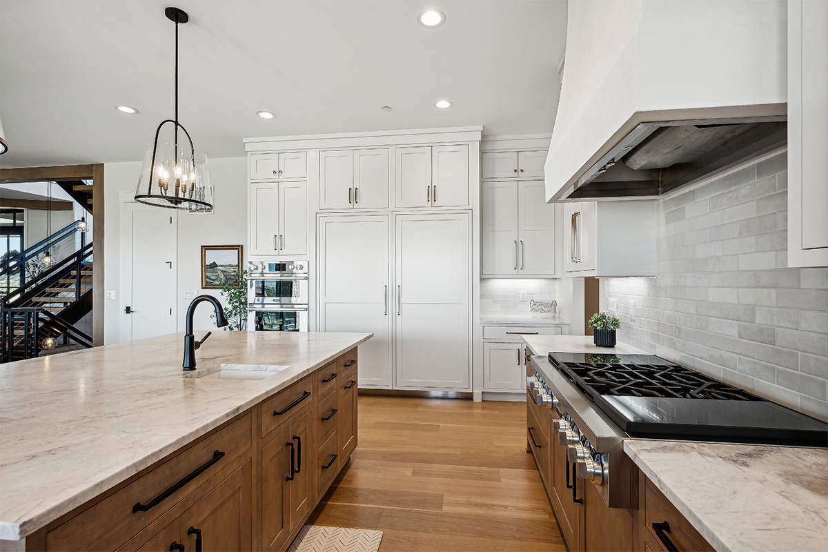 White painted and light brown stained kitchen with island.