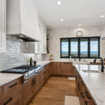 White painted and light brown stained kitchen with island.