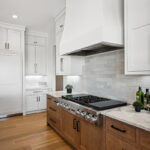 White painted and light brown stained kitchen with island.
