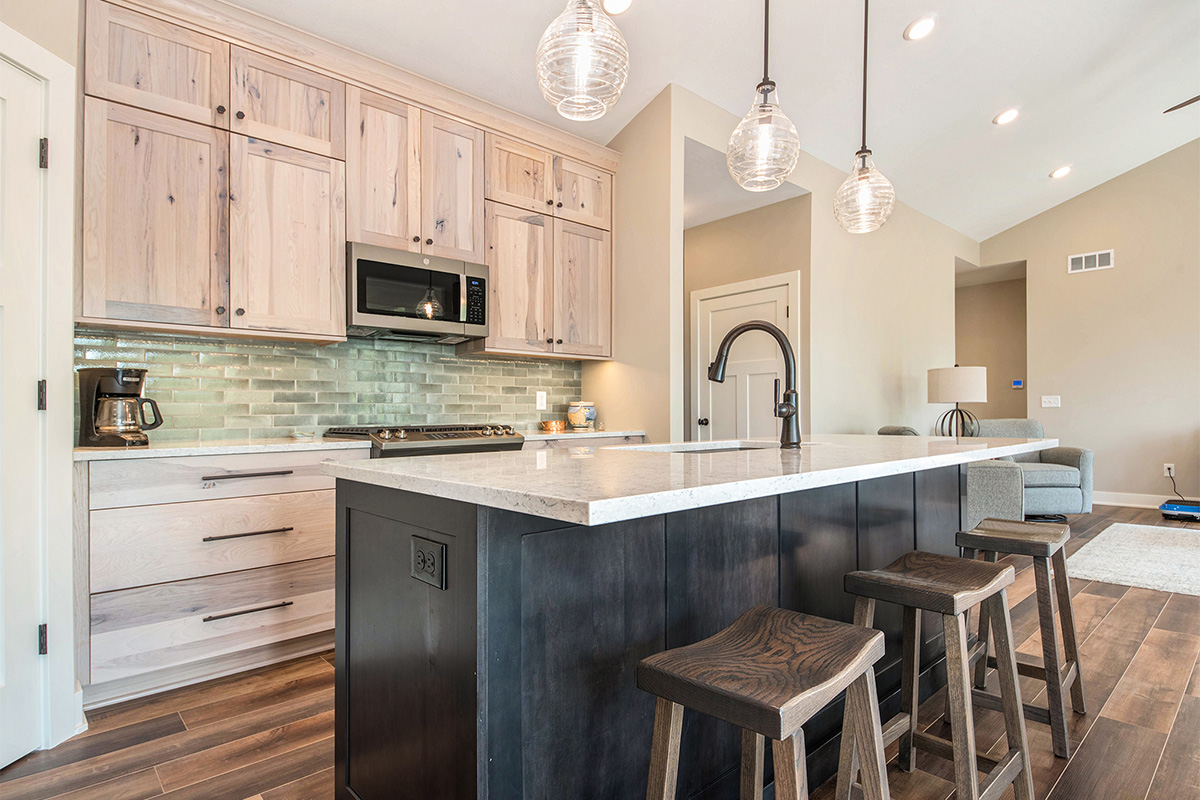 Light stain on perimeter kitchen cabinets and dark stain on island.