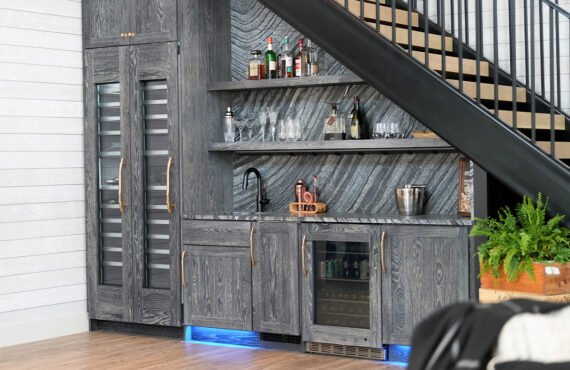 Dark stained hickory bar cabinets under a staircase