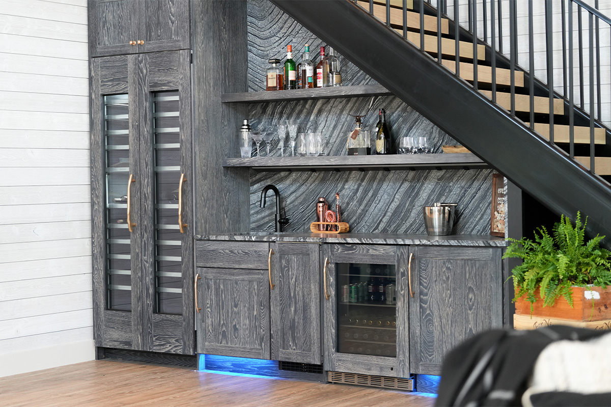 Dark stained hickory bar cabinets under a staircase