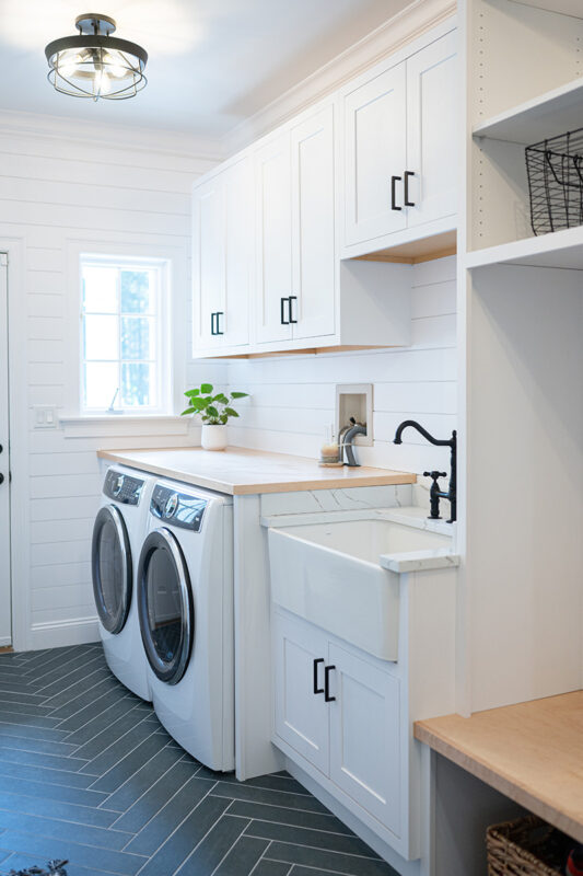 Painted white laundry/mud room with lockers.