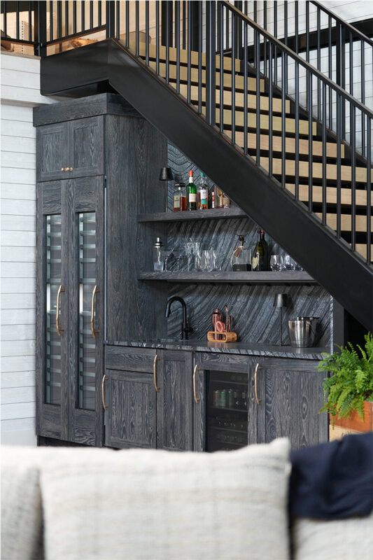 Dark stained hickory bar cabinets under a staircase