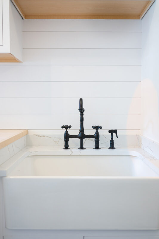 Painted white laundry/mud room with lockers.
