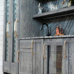 Dark stained hickory bar cabinets under a staircase