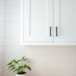 Painted white laundry/mud room with lockers.