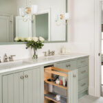 Light green painted bathroom vanity with pullout storage.
