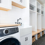 Painted white laundry/mud room with lockers.