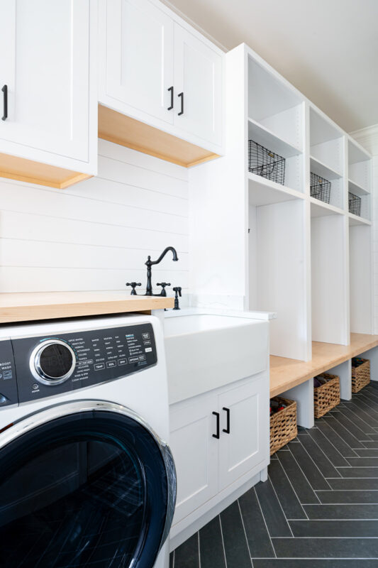 Painted white laundry/mud room with lockers.