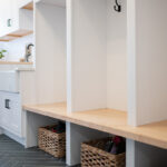 Painted white laundry/mud room with lockers.