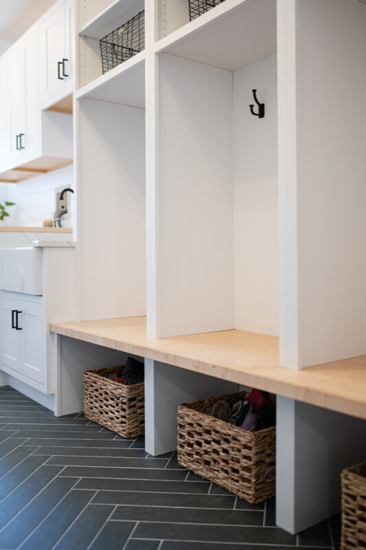 Painted white laundry/mud room with lockers.