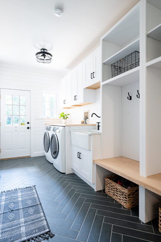 Painted white laundry/mud room with lockers.