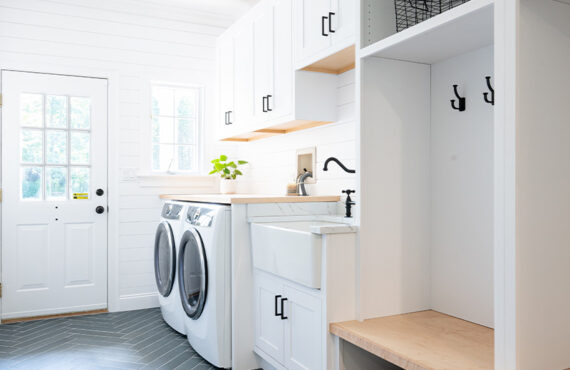 Painted white laundry/mud room with lockers.