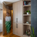 Dark brick fireplace with TV above and light stained cabinets on both sides.