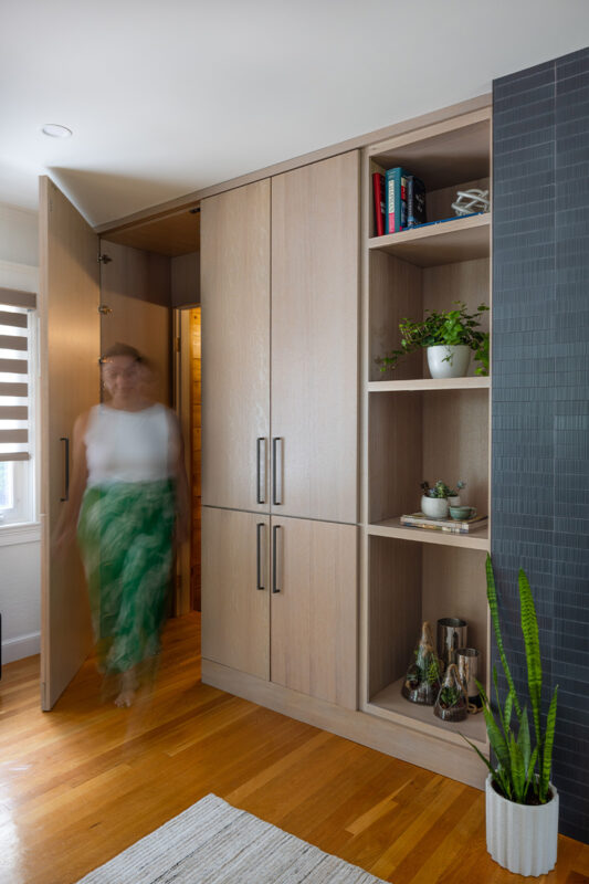Dark brick fireplace with TV above and light stained cabinets on both sides.