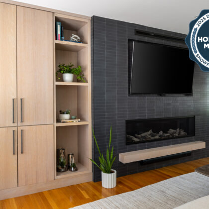 Dark brick fireplace with TV above and light stained cabinets on both sides.