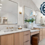 Double light brown bathroom vanities with powder desk in between.