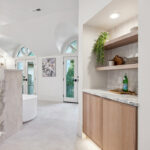 Light brown stained master bedroom cabinet with floating shelves.
